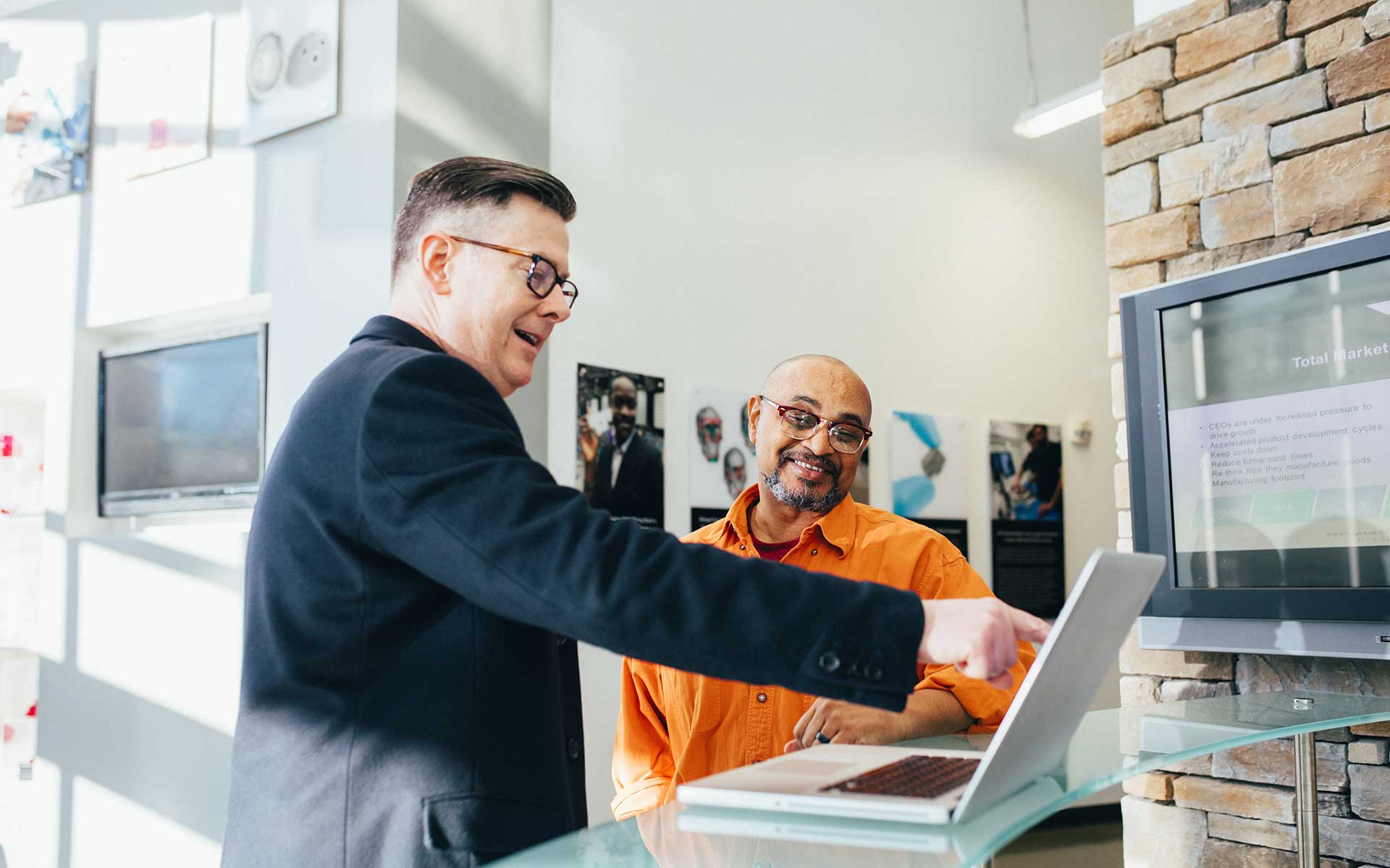 Businessmen analyze data on a laptop, supporting effective RTO compliance strategies.