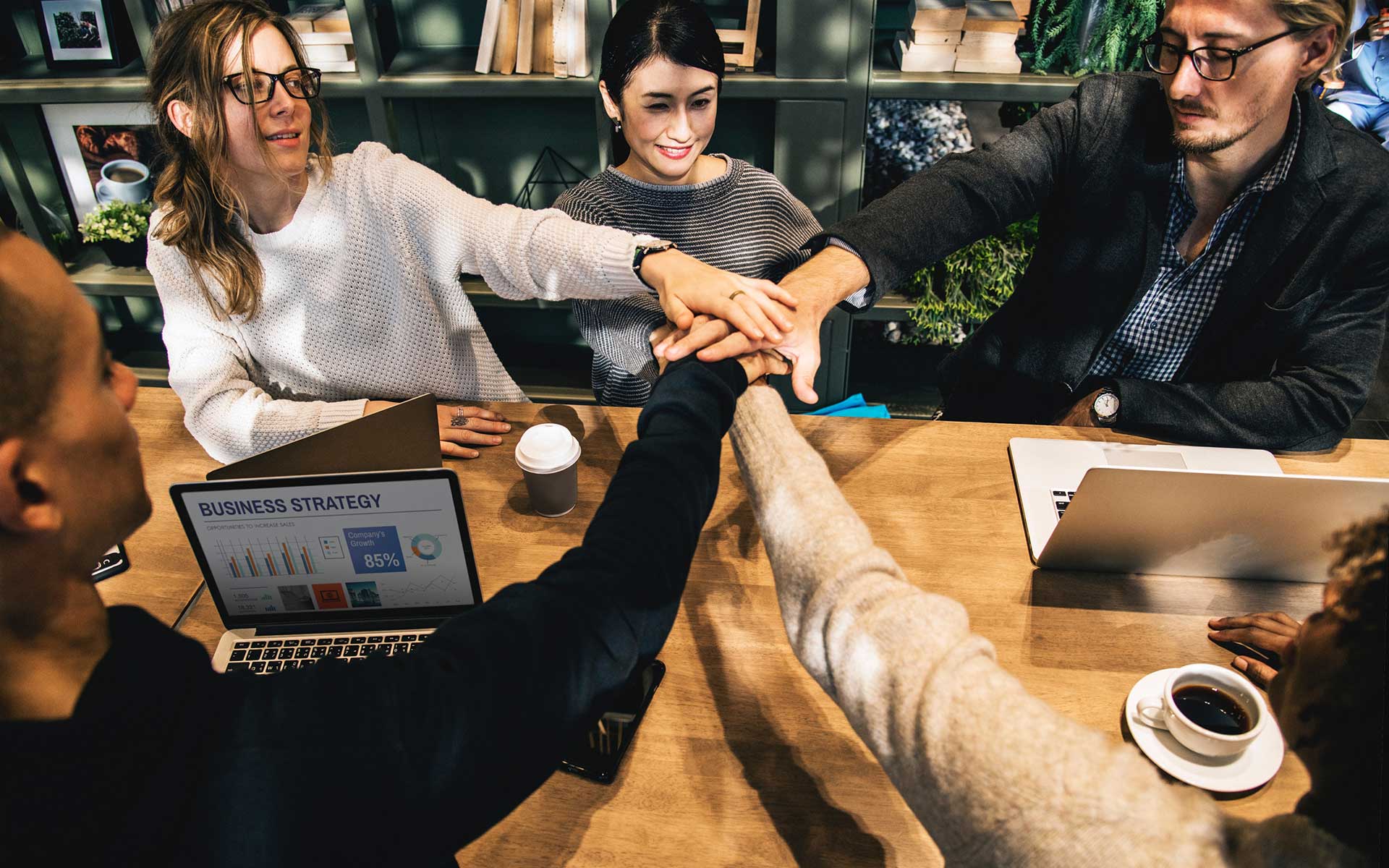 A business team discusses strategy around a laptop, showcasing effective RTO compliance.