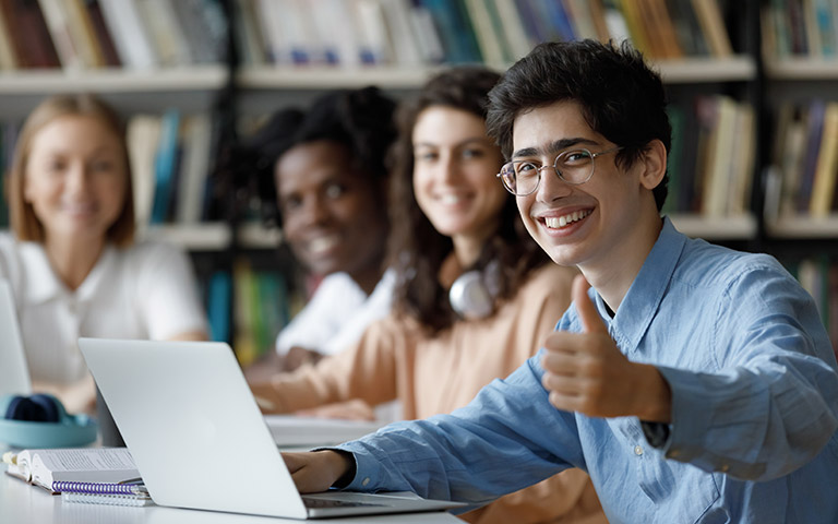 Students using laptops in a library demonstrate customised training resources for effective vet training.